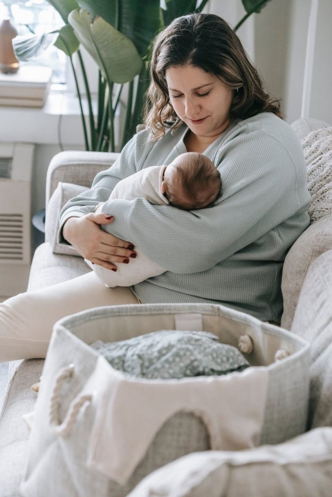 mother with newborn baby on couch