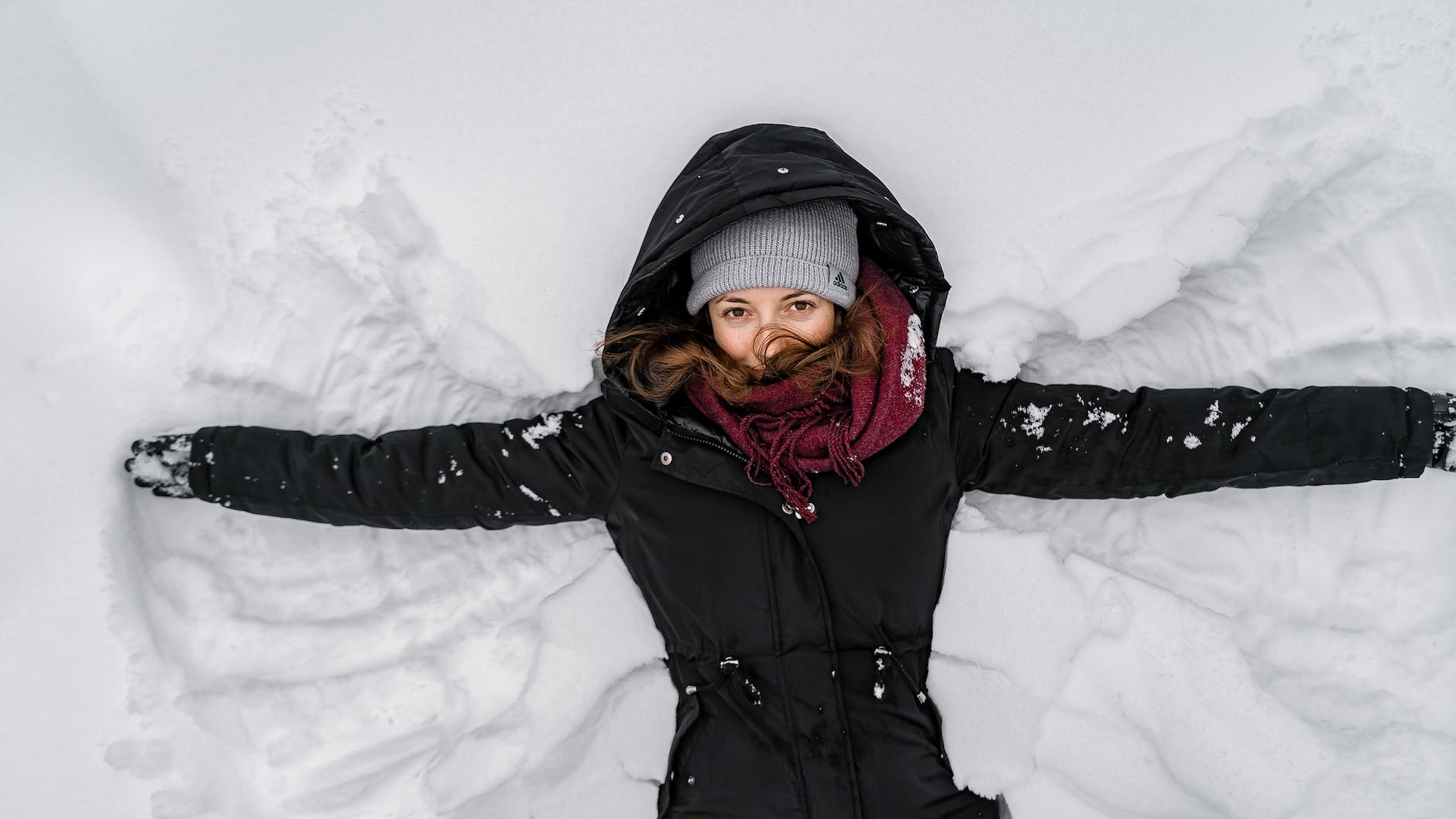 woman in black jacket and gray knit cap on snow covered ground