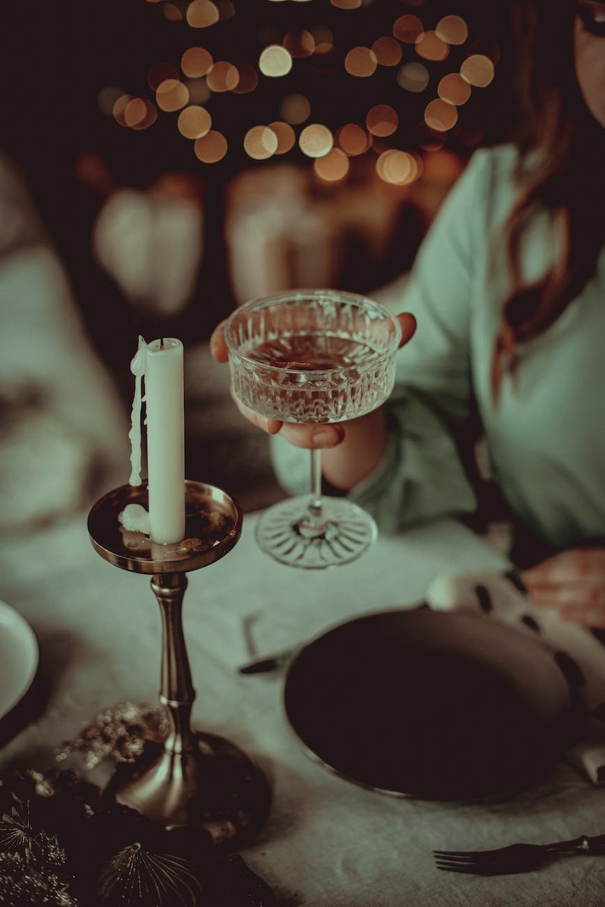 woman holding a cocktail at a christmas dinner party